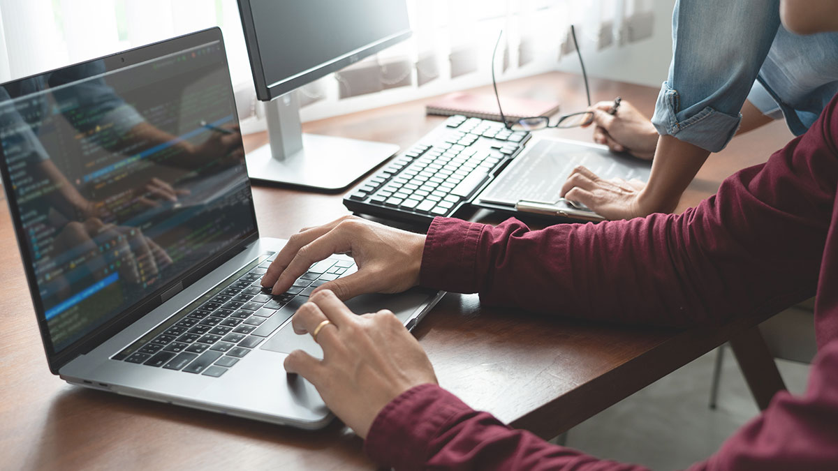 business partners coding on laptop